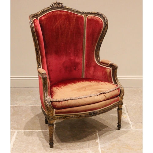 1010 - A French Louis XV style giltwood framed bergère armchair, 20th century, in red velour upholstery, th... 