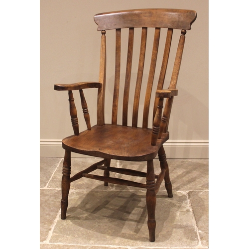 1017 - An elm and beech farmhouse Windsor elbow chair, late 19th century, the lath back over a figured elm ... 