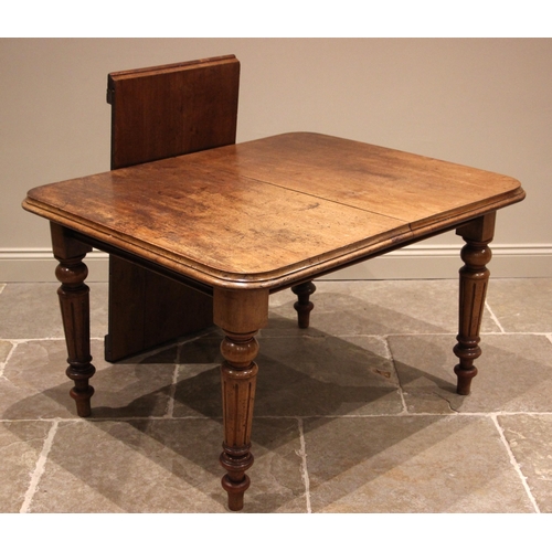 1031 - A Victorian mahogany extending dining table, the rounded rectangular top upon four fluted and turned... 