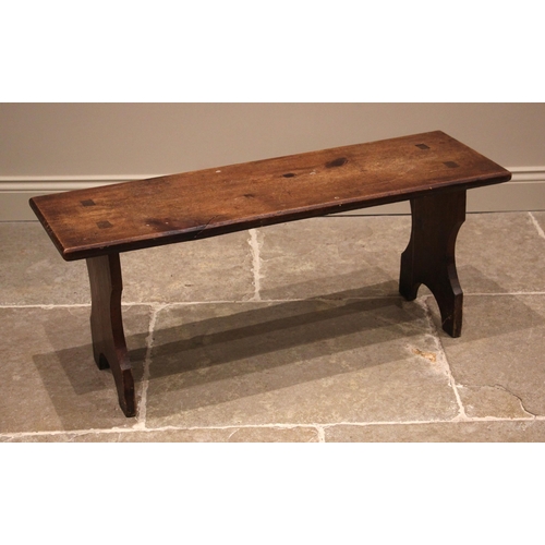 1035 - A stained pine bench, late 19th century, the rectangular top upon shaped 'U' cut trestle type suppor... 