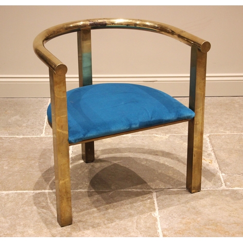 1036 - An upholstered brass framed elbow chair, late 20th century, the tubular top rail upon three legs of ... 