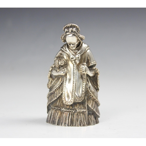 104 - A 20th century white metal novelty table bell, modelled as a well-dressed lady holding a dog and wal... 