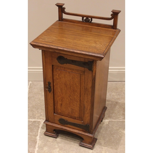 1047 - An Arts & Crafts oak pot cupboard, by Wylie and Lochhead, Glasgow, the open work top rail above a re... 