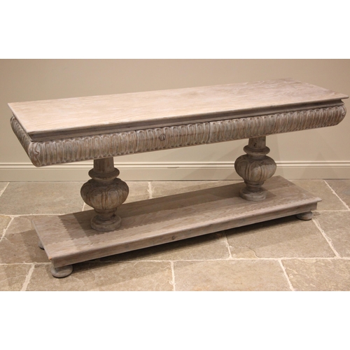 1068 - A contemporary limed oak console table in the Elizabethan style, the convex nulled frieze with twin ... 