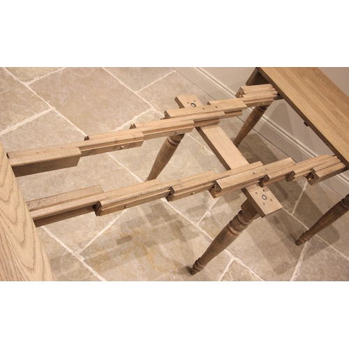 1073 - An Oka 'Charlotte' extending dining table, constructed from alder wood with a weathered oak finish, ... 