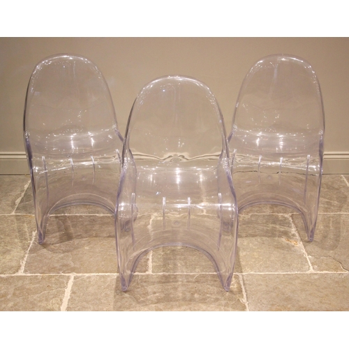 1084 - A trio of perspex stacking chairs in the manner of Philip Starck, each of curved form with back swep... 