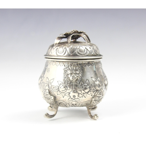 122 - A continental white metal tea caddy, the cast foliate handle upon pull off cover above a bulbous emb... 