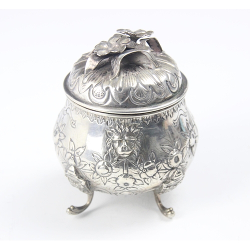 122 - A continental white metal tea caddy, the cast foliate handle upon pull off cover above a bulbous emb... 