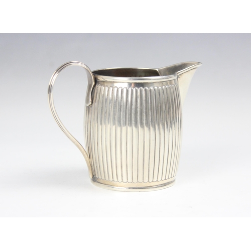 132 - A George III silver cream jug, 'HS' London 1795, the grooved barrel shaped jug with gilt interior an... 