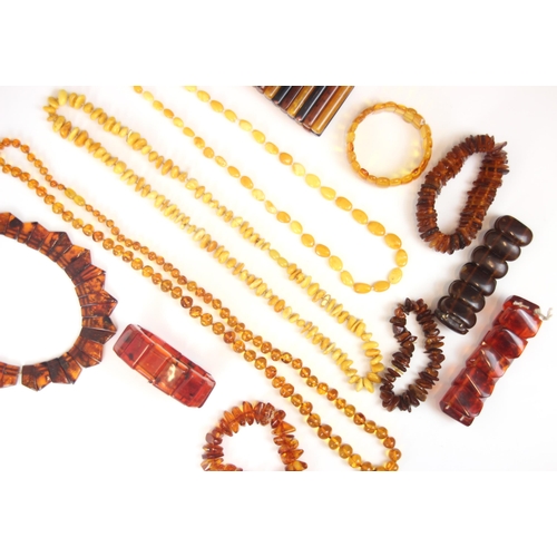 215 - A selection of amber coloured jewellery, including a panelled 'amber' coloured bracelet, a buttersco... 