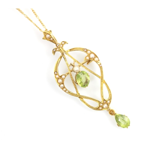 221 - A 20th century peridot and split pearl pedant/brooch, the central oval cut peridot within sinuous ye... 