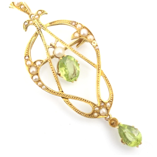 221 - A 20th century peridot and split pearl pedant/brooch, the central oval cut peridot within sinuous ye... 