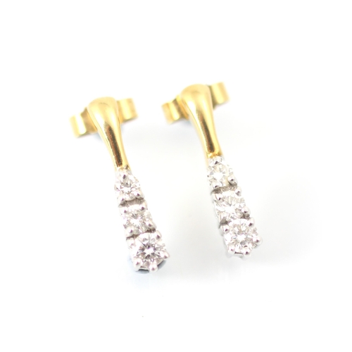 229 - A pair of diamond trilogy earrings, the yellow metal stud suspending three graduated round cut diamo... 