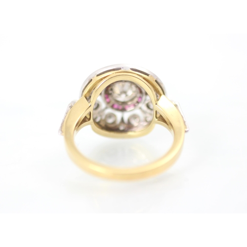 230 - An Art Deco style diamond and ruby target ring, the central round cut diamond within a surround of c... 