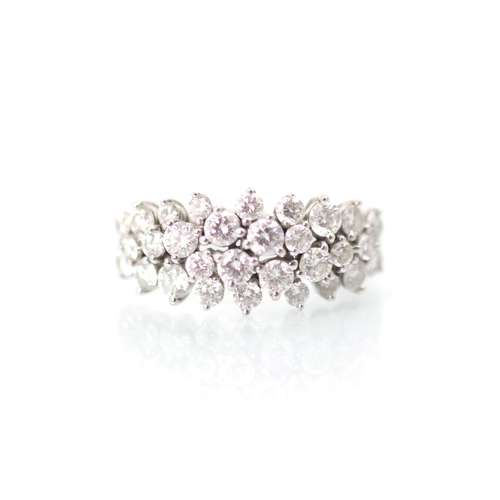 232 - A stylised diamond cluster ring, the graduated round cut diamonds set within a raised claw set mount... 