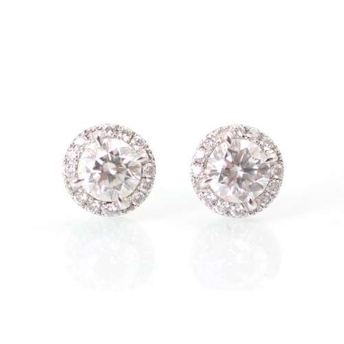 239 - A pair of diamond stud earrings, the round cut diamond within a surround of further smaller round cu... 