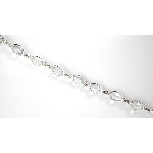 241 - An aquamarine set bracelet, the sixteen oval cut stones within rub over white metal edge, with lobst... 