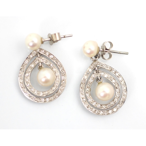 242 - A pair of 20th century style diamond and cultured pearl earrings, the cultured pearl studs suspendin... 