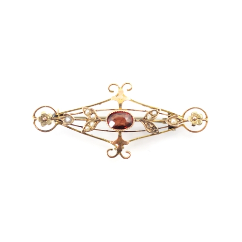 247 - An Edwardian style garnet bar brooch, the oval cut garnet within openwork mount with split pearl lea... 