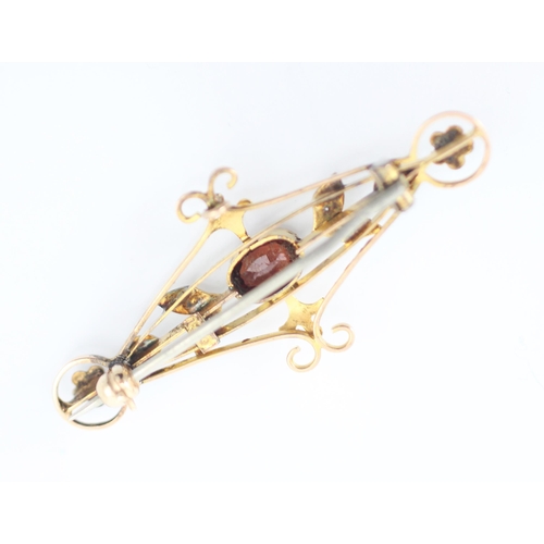 247 - An Edwardian style garnet bar brooch, the oval cut garnet within openwork mount with split pearl lea... 