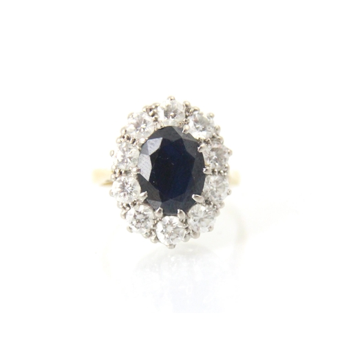 253 - An Edwardian style sapphire and diamond cluster ring, the central oval cut sapphire claw set in whit... 