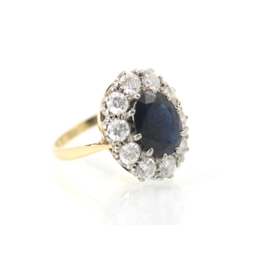 253 - An Edwardian style sapphire and diamond cluster ring, the central oval cut sapphire claw set in whit... 