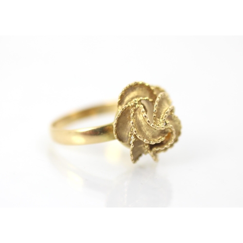 266 - A yellow metal dress ring, the knot designed head with matte and polished frilled detail, set to pla... 