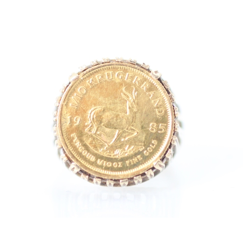 267 - A 1/10 krugerrand coin set ring, the coin dated 1985 within a openwork 9ct mount and plain polished ... 