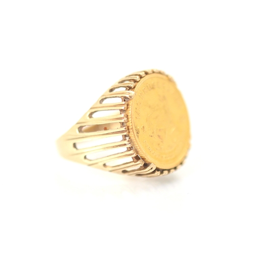 267 - A 1/10 krugerrand coin set ring, the coin dated 1985 within a openwork 9ct mount and plain polished ... 