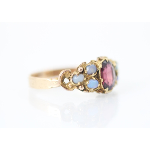 272 - A 19th century garnet and opal ring, the central oval cut garnet within claw setting edge with three... 