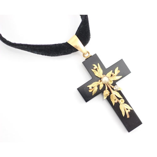 287 - A 19th century style cross pendant, the black glass cross with applied two tone yellow metal leaf de... 