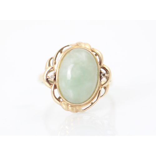 294 - A 9ct yellow gold green hardstone ring, the oval cabochon green stone within sinuous yellow gold mou... 