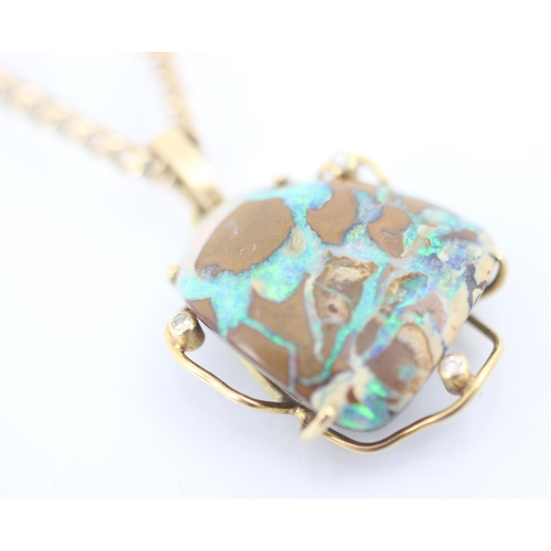 295 - A yellow metal mounted boulder opal pendant, the organic shaped opal within sinuous mount with diamo... 