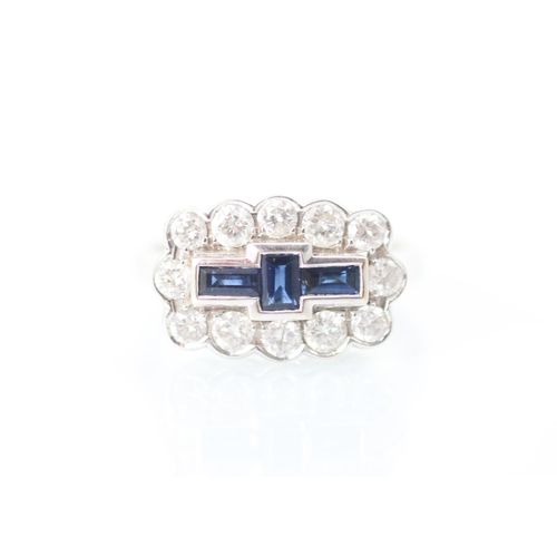 303 - An 18ct white gold sapphire and diamond dress ring, the three baguette cut sapphires within surround... 