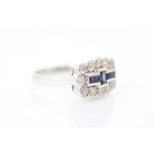 303 - An 18ct white gold sapphire and diamond dress ring, the three baguette cut sapphires within surround... 