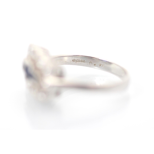 303 - An 18ct white gold sapphire and diamond dress ring, the three baguette cut sapphires within surround... 