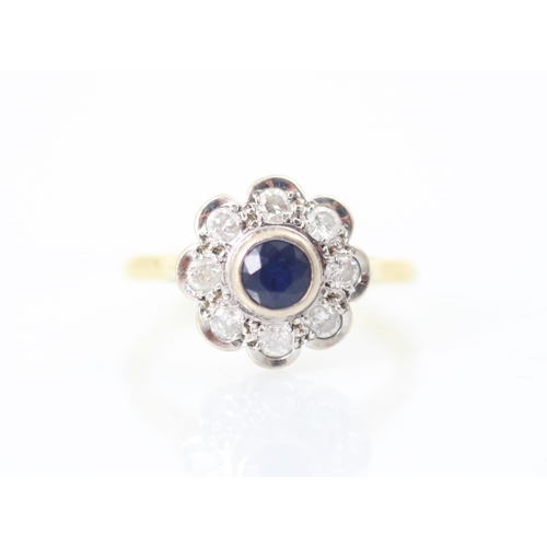 308 - A 20th century style sapphire and diamond cluster ring, the round cut sapphire within white metal ru... 