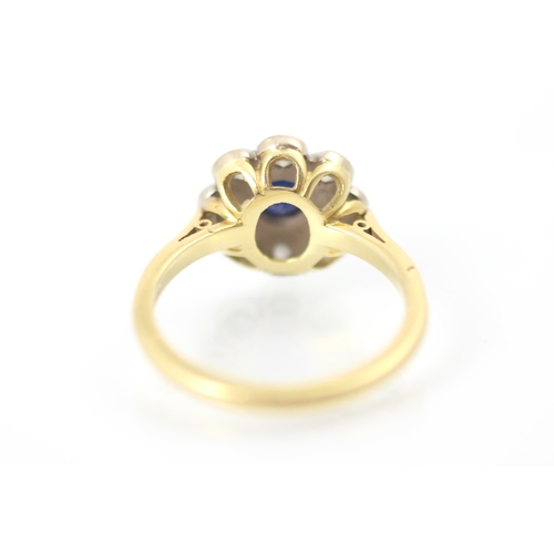 308 - A 20th century style sapphire and diamond cluster ring, the round cut sapphire within white metal ru... 