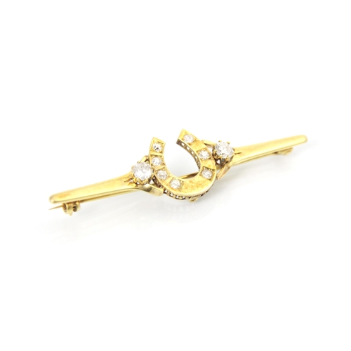 315 - A yellow metal diamond set bar brooch, the round cut diamonds set within a horse shoe designed head ... 