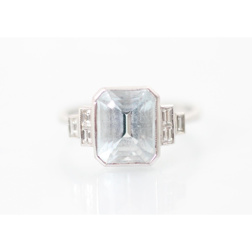 320 - An Art Deco style aquamarine and diamond ring, the central emerald cut aquamarine in rub over white ... 