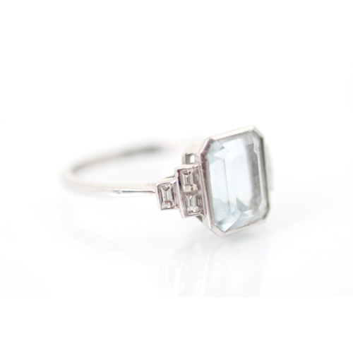 320 - An Art Deco style aquamarine and diamond ring, the central emerald cut aquamarine in rub over white ... 