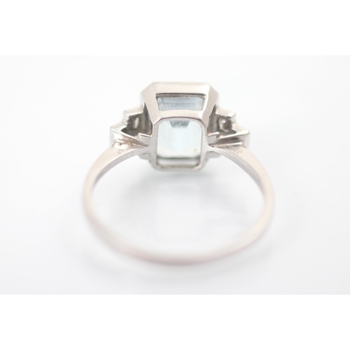 320 - An Art Deco style aquamarine and diamond ring, the central emerald cut aquamarine in rub over white ... 