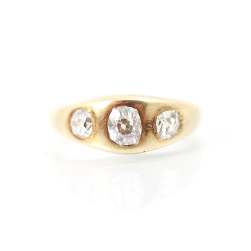 323 - An early 20th century yellow metal and diamond three stone gypsy set ring, the central old cut diamo... 