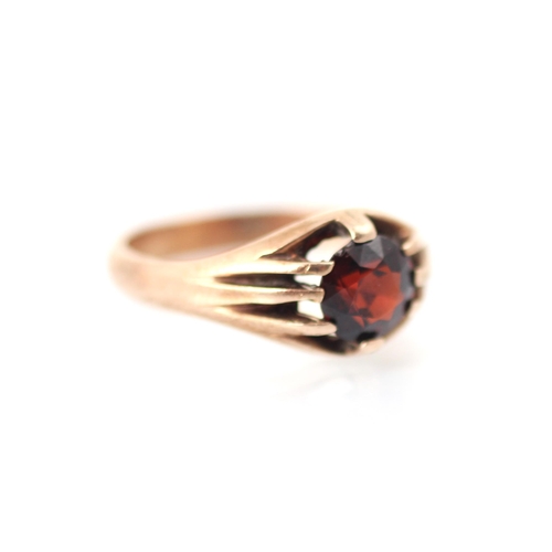 324 - A 20th century style synthetic ruby gypsy set ring, the round cut red stone within claw set grooved ... 