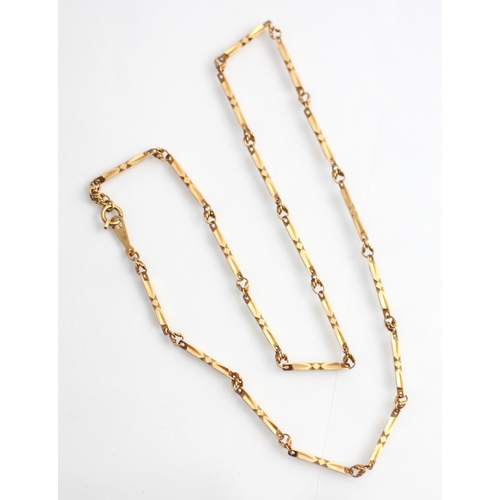 329 - A yellow metal necklace, the shaped faceted rectangular links interspersed with circular stylised li... 