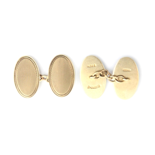 336 - A pair of 9ct yellow gold cufflinks, the oval links with stylised sun ray decoration, stamped to rev... 