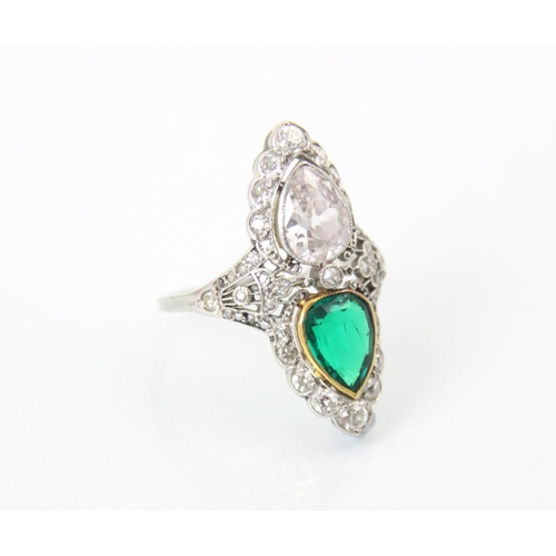 339 - A ‘Belle Epoque’ emerald and diamond set ring, the old cut pear cut diamond within white metal milgr... 