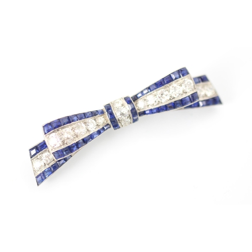 340 - An early 20th century sapphire and diamond ribbon brooch, the central line of old cut diamonds with ... 