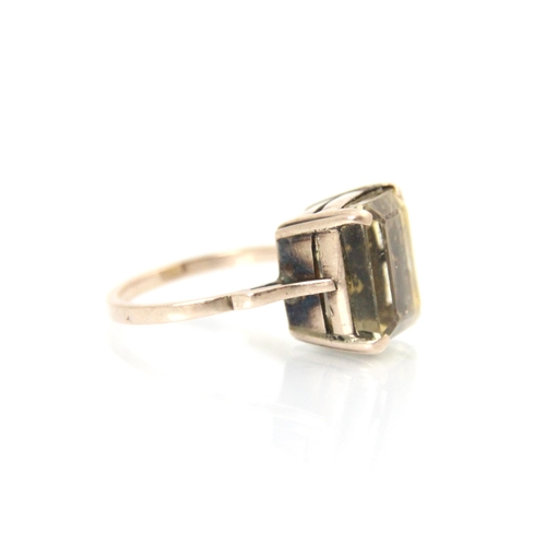 345 - A citrine dress ring, the emerald cut citrine within yellow metal four claw setting, leading to plai... 