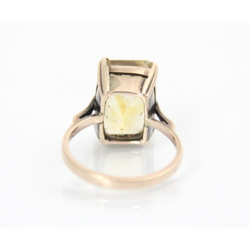 345 - A citrine dress ring, the emerald cut citrine within yellow metal four claw setting, leading to plai... 